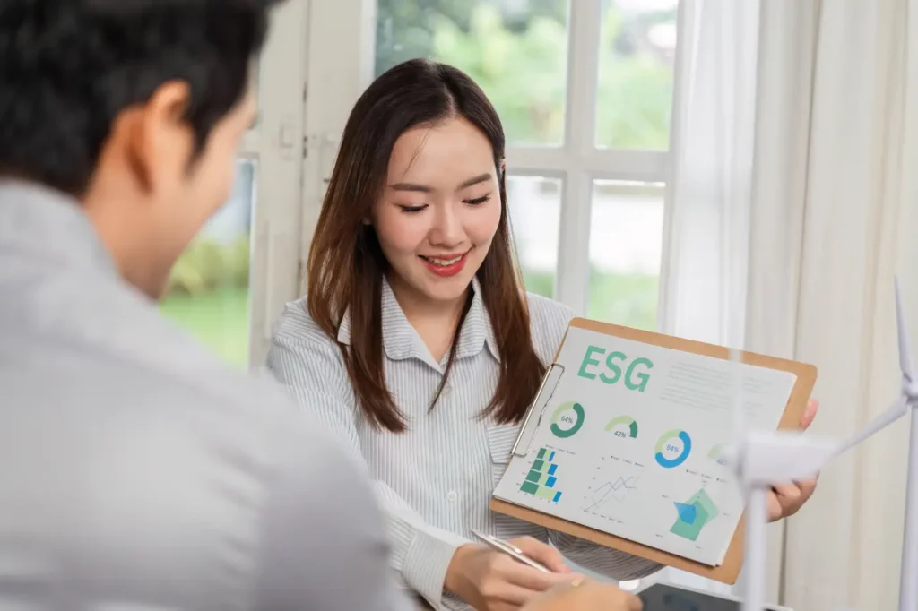 Consultant presenting ESG reporting insights to a client during a business meeting in Singapore.