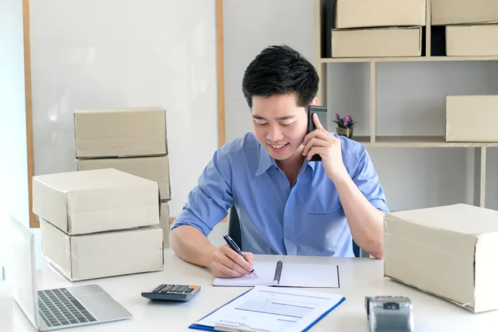 Business owner reviewing paperwork and calculations related to tax services in Singapore